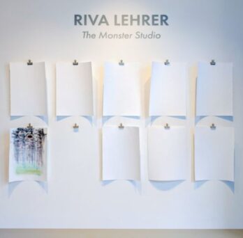 A white wall contains the text: RIVA LEHRER The Monster Studio. The wall has nine pieces of white paper in two rows hanging from silver bulldog clips. All the paper is blank except for one that contains a chromatic, abstract drawing. There is an empty bulldog clip where the next completed drawing will hang.
                  